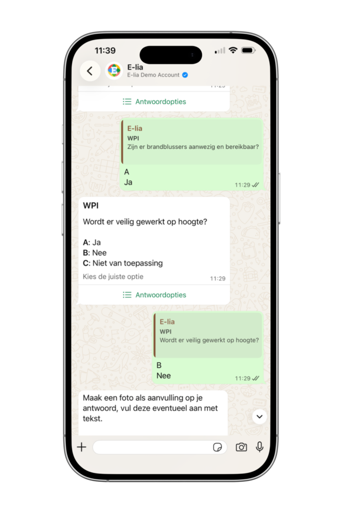 Smartphone met een LMRA (Laatste Minuut Risico Analyse) via WhatsApp: E-lia stelt korte veiligheidsvragen, zoals of brandblussers aanwezig en bereikbaar zijn en of er veilig op hoogte wordt gewerkt, met keuzeopties.